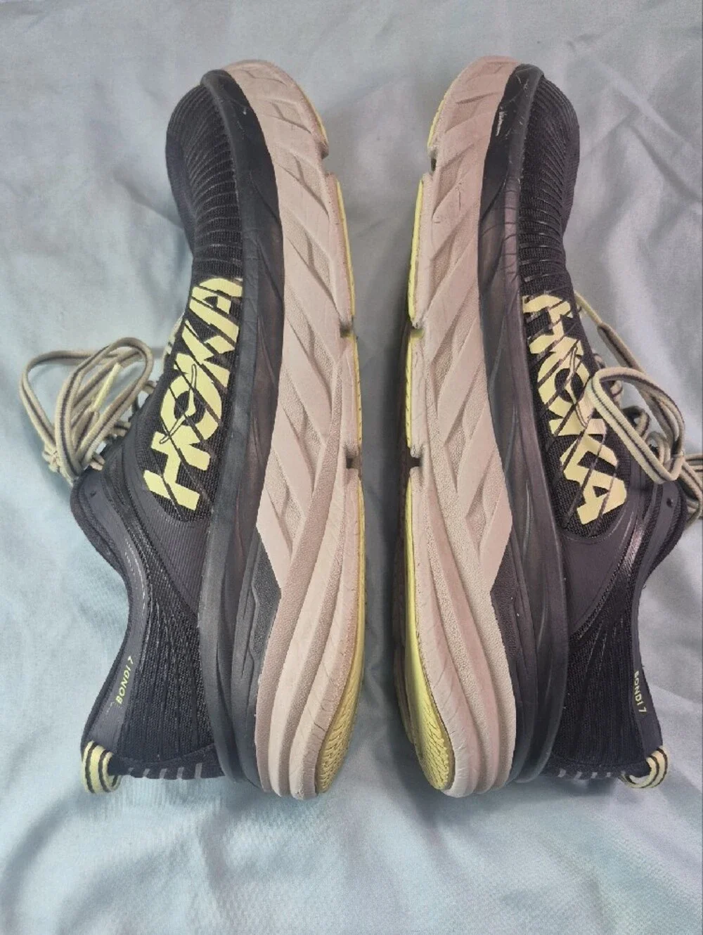 Hoka black running shoes with pale yellow logo